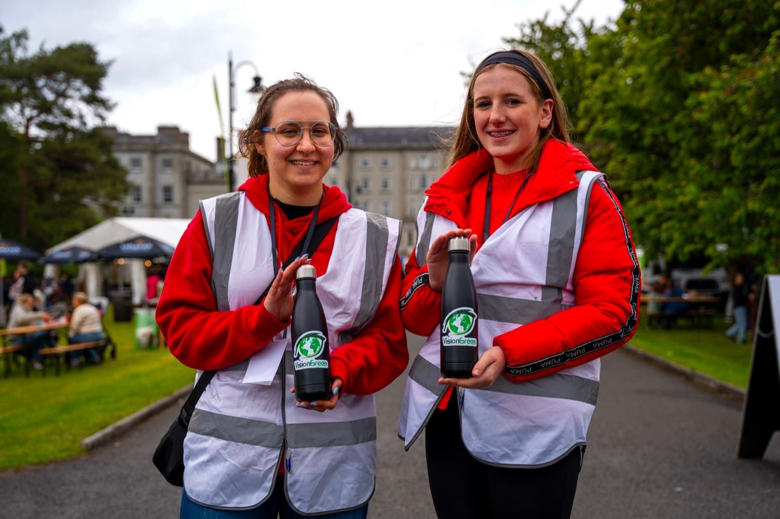 Two VisionGreen volunteers in high-visibility vests at the Carlow Arts Festival.